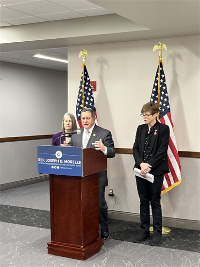 Congressman Morelle, Michelle Casey, and Kim Pandina stand at a podum in front of two American flags.