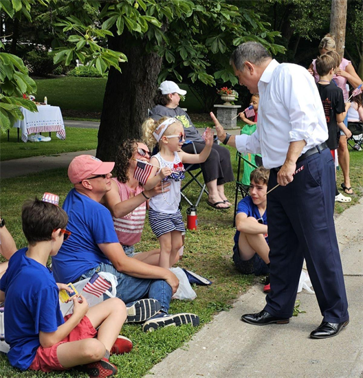 Rep. Morelle high fives a community member at a fourth of july event